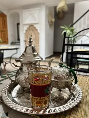 a tray with a tea kettle and a cup on a table at Riad Sarah Sabrina in Marrakech