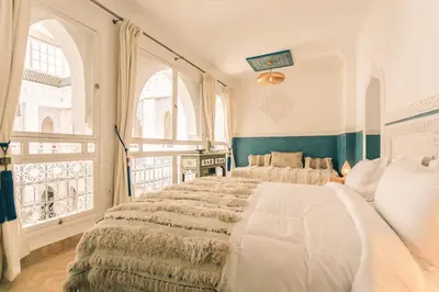 a bedroom with a large bed in a room with windows at Riad Zeitoun Palace in Marrakech