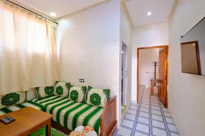 a living room with a green couch and a table at Hotel Central Palace in Marrakech