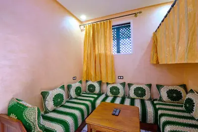 a room with green and white chairs and a table at Hotel Central Palace in Marrakech