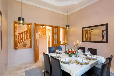 a dining room with a long table and chairs at La Palmeraie De L'Atlas in Marrakech