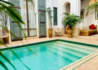 a swimming pool in front of a house at Riad Jardin Des Sens & Spa in Marrakech