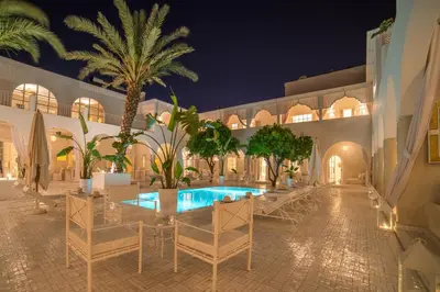 a resort with a swimming pool at night at Riad Palais Blanc & Spa in Marrakech