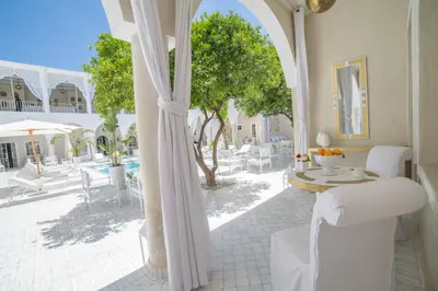 a room with a patio with a table and chairs at Riad Palais Blanc & Spa in Marrakech