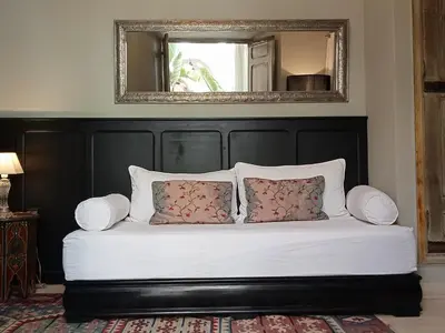 a bed with a black headboard and two pillows at Dar al Sultan in Marrakech