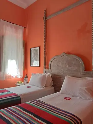two beds in a room with orange walls at Dar al Sultan in Marrakech