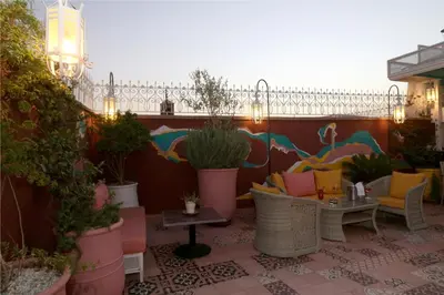 a patio with chairs and tables and potted plants at Riad Karmela Princesse in Marrakech