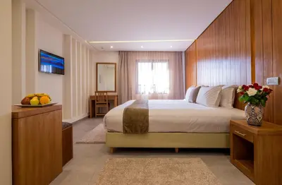 a bedroom with a large bed and a vase of flowers at Hotel Ayoub & Spa in Marrakech