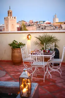 a patio with two chairs and a table with candles at Astra Damus Hotel in Marrakech