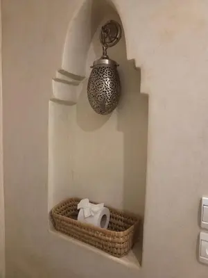 a room with a shelf with a vase and a light at Riad Laly Tourisme Eclairé Le bijou de la medina in Marrakech