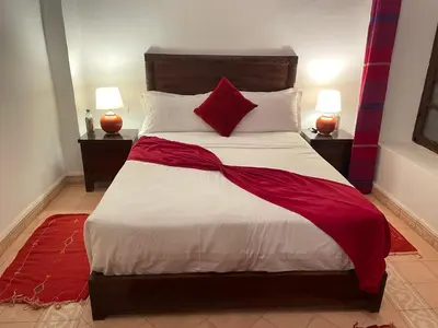 a bedroom with a large bed with red and white sheets at Riad Safia in Marrakech