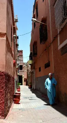 a man walking down a street in an alley at Dar Yasser in Marrakech