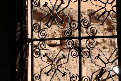 an iron gate with a view of a window at Dar Yasser in Marrakech