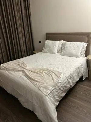 a bed with a white comforter and pillows at Appartement Privé au Vizir Center Marrakech in Marrakech