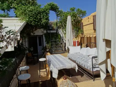 an outdoor patio with a couch and an umbrella at Riad Dar Oulhoum in Marrakech
