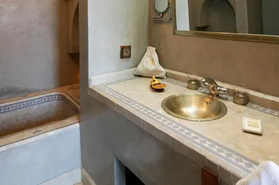 a bathroom counter with a sink and a mirror at Riad Alili in Marrakech