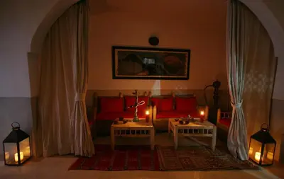 a living room with a couch and two tables with candles at Riad Alili in Marrakech