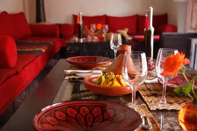a table with wine glasses and a bowl of fruit at Riad Alili in Marrakech