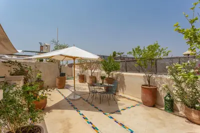 a patio with a table and an umbrella at Riad Azahar in Marrakech