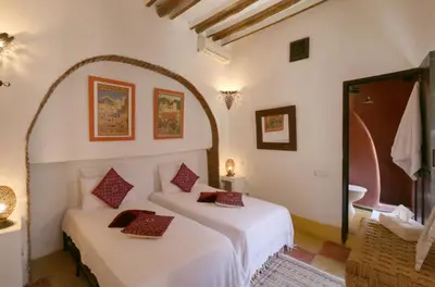 a bedroom with two beds and a bathroom at Riad Merstane Marrakech in Marrakech