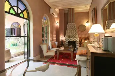 a living room with a bird on a glass table at Riad Merstane Marrakech in Marrakech