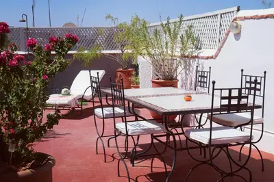 a patio with a table and chairs and flowers at Riad Merstane Marrakech in Marrakech