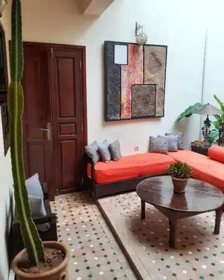 a room with a bed and a table and a cactus at Color Safrà in Marrakech