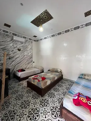 a bedroom with two beds and a wall mural at Kasbah Red Castel Hostel in Marrakech