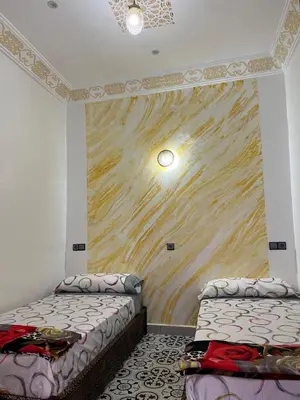 a room with two beds and a painting on the wall at Kasbah Red Castel Hostel in Marrakech