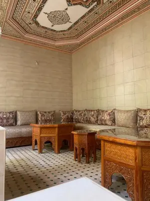 a living room with a couch and tables and a ceiling at Riad Tidar by Phoenix in Marrakech