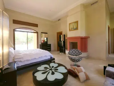 a bedroom with a large bed and a fireplace at Maison d'hote Oceania in Marrakech