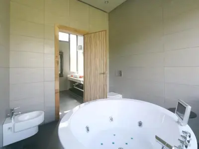 a bathroom with a large white tub and a sink at Maison d'hote Oceania in Marrakech