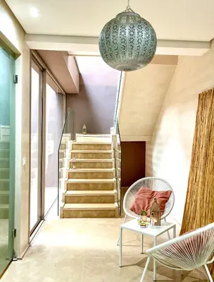 a living room with a staircase and a chandelier at Villa Jardins D'Isa in Marrakech