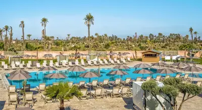 a pool with chairs and umbrellas at a resort at Be Live Collection Marrakech Adults Only All inclusive in Marrakech