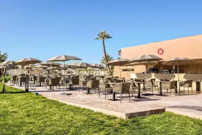 a row of chairs and umbrellas in front of a building at Be Live Collection Marrakech Adults Only All inclusive in Marrakech