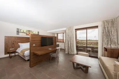 a hotel room with a bed and a desk with a television at Be Live Experience Marrakech Palmeraie - All Inclusive in Marrakech
