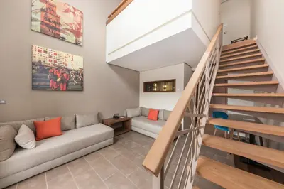 a living room with a couch and stairs at Be Live Experience Marrakech Palmeraie - All Inclusive in Marrakech