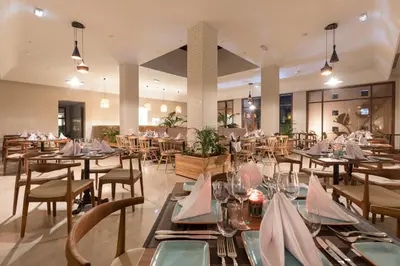 a dining room with tables and chairs in a restaurant at Be Live Experience Marrakech Palmeraie - All Inclusive in Marrakech