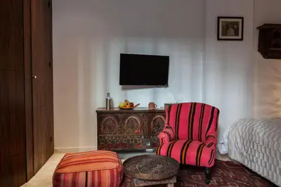a living room with a chair and a tv at Riad Zebrakaro in Marrakech