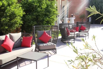 a group of chairs with red pillows on a patio at Kenzi Club Agdal Medina - All Inclusive in Marrakech