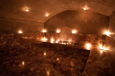 a room with candles on a stone wall with a table at Kenzi Club Agdal Medina - All Inclusive in Marrakech