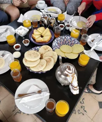 a table with plates of food and drinks on it at Riad Salma Restaurant Spa in Marrakech
