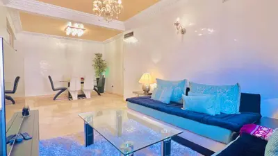 a living room with a blue couch and a table at Sabor Apartments Anas Majorelle in Marrakech