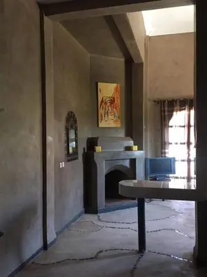 a living room with a fireplace and a table at Les Résidences Du Domaine in Marrakech