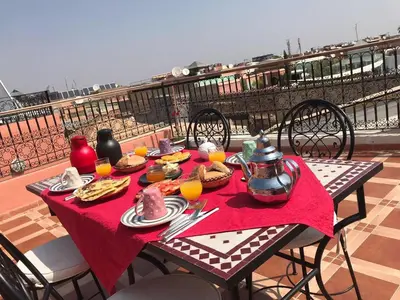 a table with food and orange juice on a balcony at Hostel Amour d'auberge in Marrakech