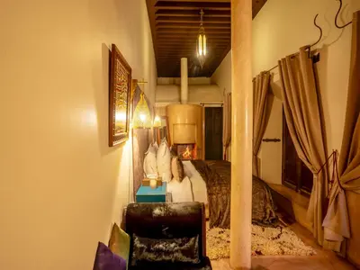 a bedroom with a bed and a chair in a room at Riad Ines Home in Marrakech