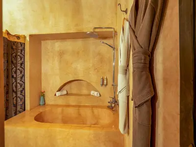 a bathroom with a bath tub with a shower at Riad Ines Home in Marrakech