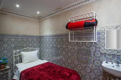 a bedroom with a bed and a sink in it at Hotel Zitoune in Marrakech