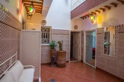 a living room with a couch and a mirror at Hotel Zitoune in Marrakech