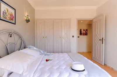 a white bed with a hat on top of it at In Club Palmeraie Resorts in Marrakech